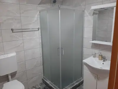 a bathroom with a shower and a toilet and a sink at Apartmani Miodragović - nedaleko od Snežnika, 100 metara pre bazena in Vrnjačka Banja
