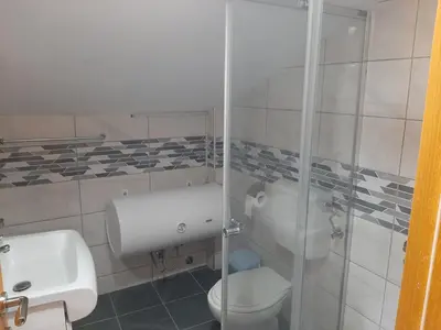 a bathroom with a toilet and a sink at Apartmani Miodragović - nedaleko od Snežnika, 100 metara pre bazena in Vrnjačka Banja