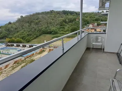 a balcony with a chair and a view of a mountain at IL Paradiso potok akva park in Jagodina