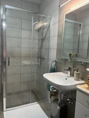 a bathroom with a shower and a sink and a mirror at IL Paradiso potok akva park in Jagodina