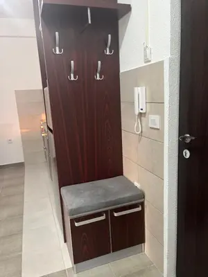 a bathroom with a wooden cabinet with a bench at IL Paradiso potok akva park in Jagodina