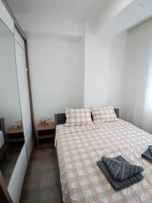 a bedroom with a bed with a blanket and a mirror at IL Paradiso potok akva park in Jagodina