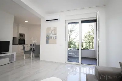 a living room with white walls and a large sliding glass door at Aqua Vista Lux Raj in Vrnjačka Banja