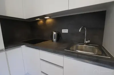 a kitchen with a stainless steel sink and white cabinets at Aqua Vista Lux Raj in Vrnjačka Banja