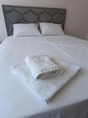 a bed with two towels sitting on top of it at Eli's apartment in Niš