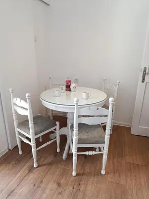 a white table with two chairs and a white table with cups at Eli's apartment in Niš