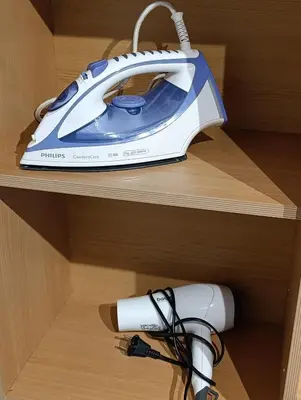 a blue and white iron sitting on top of a drawer at Eli's apartment in Niš