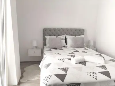 a bedroom with a bed with a black and white quilt at Apartman Simijonovic in Trnava