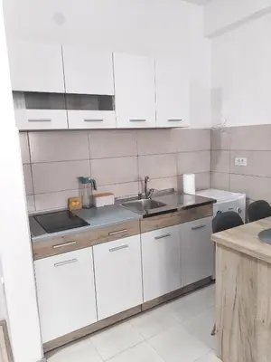 a kitchen with white cabinets and a sink at Apartman Simijonovic in Trnava