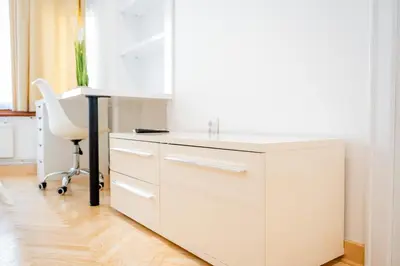 a white kitchen with a desk and a chair at Apartman Simonovic in Vrnjačka Banja