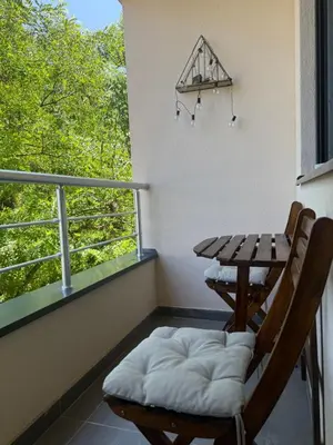 a balcony with a table and two chairs and a window at Tajna Ozrena - Sokobanja in Soko Banja