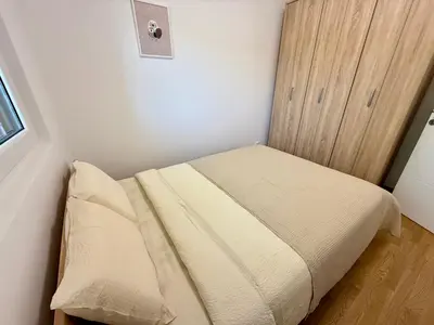 a small bedroom with a bed and a wooden cabinet at Tajna Ozrena - Sokobanja in Soko Banja