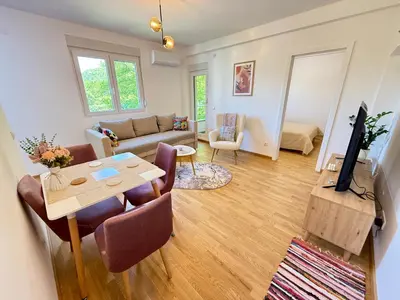 a living room with a table and a couch at Tajna Ozrena - Sokobanja in Soko Banja
