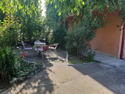 a patio with a table and chairs in a garden at Anika in Soko Banja