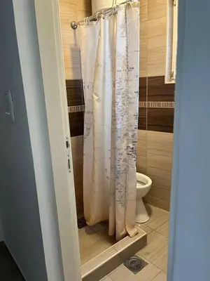 a shower curtain in a bathroom with a toilet at Na Banjici in Soko Banja