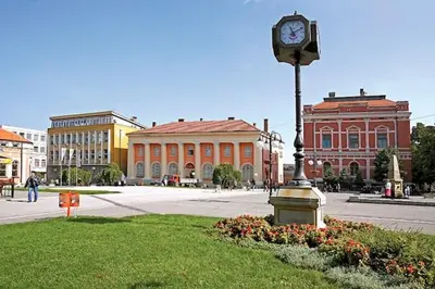 a clock on a pole in front of a building at Luxury apartment in the city center in Zaječar
