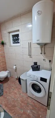 a bathroom with a washing machine and a toilet at Luxury apartment in the city center in Zaječar