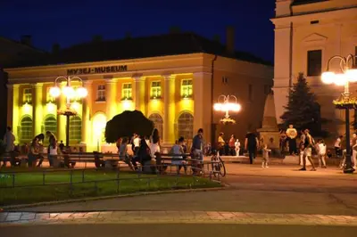 a building with people standing outside of it at night at Luxury apartment in the city center in Zaječar