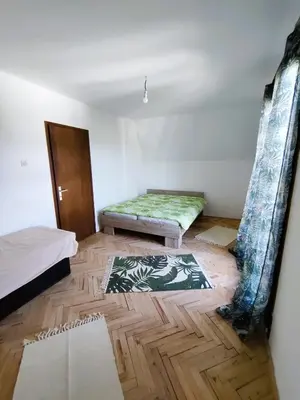 a room with two beds and a wooden floor at Vikendica Nina in Bor