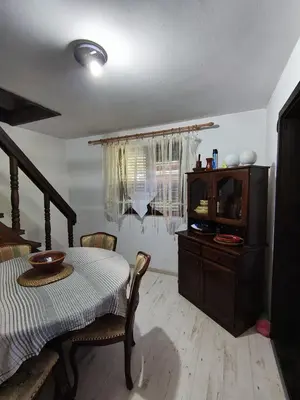a dining room with a table and a television at Vikendica Nina in Bor