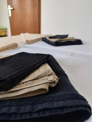 a pile of towels sitting on top of a bed at Vikendica Nina in Bor