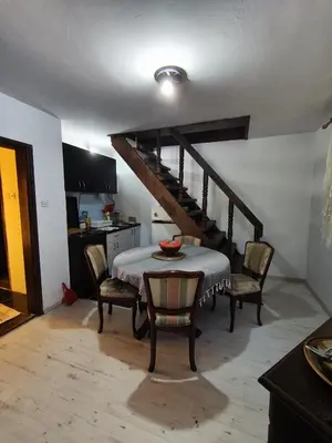 a dining room with a table and a staircase at Vikendica Nina in Bor