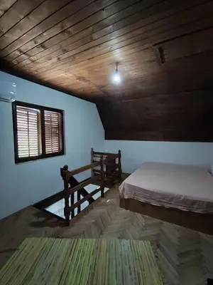 a room with two beds and a wooden ceiling at Vikendica Nina in Bor
