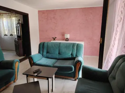 a living room with a green couch and a table at Vikendica Nina in Bor