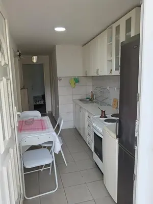 a kitchen with a table and a table and a refrigerator at Sobe Paunović in Soko Banja