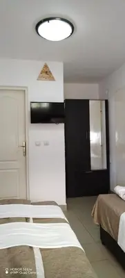 a hotel room with two beds and a light at Sobe Paunović in Soko Banja