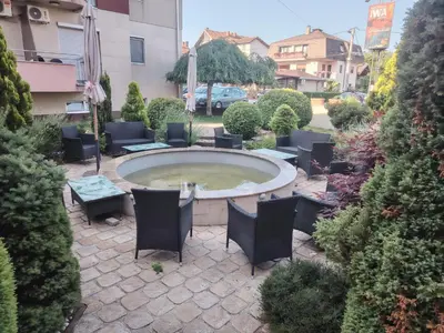 an outdoor patio with chairs and a large circular pool at Apartman Milosavljevic in Vrnjci