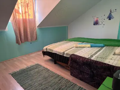 a bedroom with a bed with a green comforter at Apartmani Radovanovic in Soko Banja