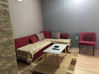 a living room with a red couch and a red chair at Apartmani Radovanovic in Soko Banja