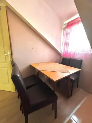 a table and chairs in a small room with a window at Apartmani Radovanovic in Soko Banja
