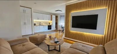 a living room with a couch and a television on a wall at Sanela's Peace in Vrnjačka Banja