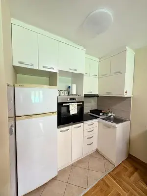 a kitchen with white cabinets and a white refrigerator at Vrnjacki kutak in Vrnjačka Banja