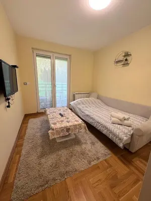 a bedroom with a bed and a tv and a table at Vrnjacki kutak in Vrnjačka Banja