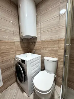 a bathroom with a toilet and a washing machine at Vrnjacki kutak in Vrnjačka Banja