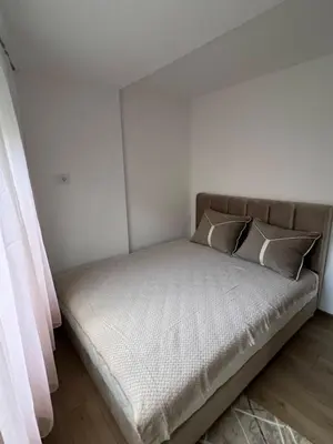 a bed with two pillows on it in a room at Apartman Porodična priča in Vrnjačka Banja