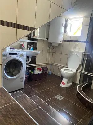 a bathroom with a washing machine and a toilet at Apartman Porodična priča in Vrnjačka Banja