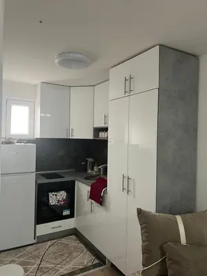 a kitchen with white cabinets and a stove top oven at Apartman Porodična priča in Vrnjačka Banja