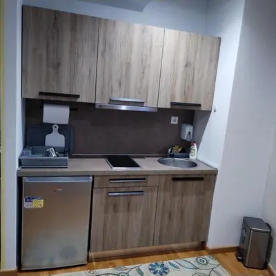 a kitchen with wooden cabinets and a sink at Apartman Iva Brzeće-Kopaonik in Brzeće
