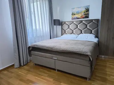 a bedroom with a large bed with a large window at Apartman Iva Brzeće-Kopaonik in Brzeće