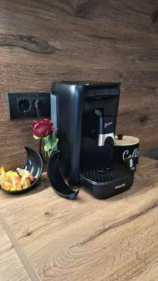 a coffee maker sitting on top of a wooden table at Luna Residence in Niš