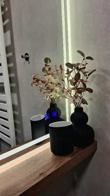 three black vases sitting on a wooden shelf at Luna Residence in Niš