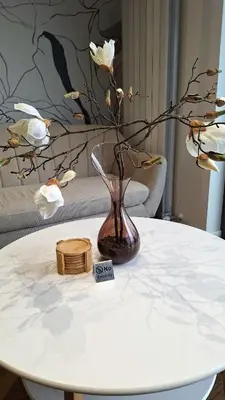 a white table with a vase with flowers on it at Luna Residence in Niš