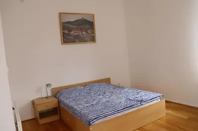 a bedroom with a bed and a picture on the wall at Apartmani 