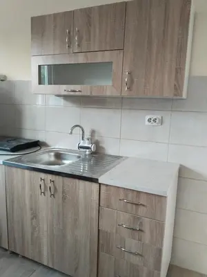 a kitchen with a sink and wooden cabinets at Čardak Zaječar in Zaječar