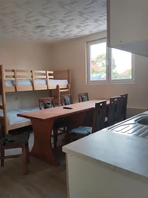 a room with a table and chairs and bunk beds at Čardak Zaječar in Zaječar