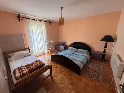 a bedroom with a bed and a bench in it at Kuća za odmor braća Jevtić Vrnjačka Banja in Vrnjačka Banja